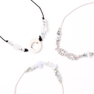 Card of 3 grey and black corded bracelets with stone chips and charms