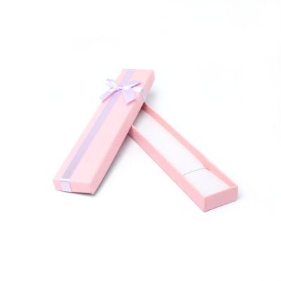 Bracelet / Pen box. 21x4x1.8cm. Textured pink box with lilac bow.
