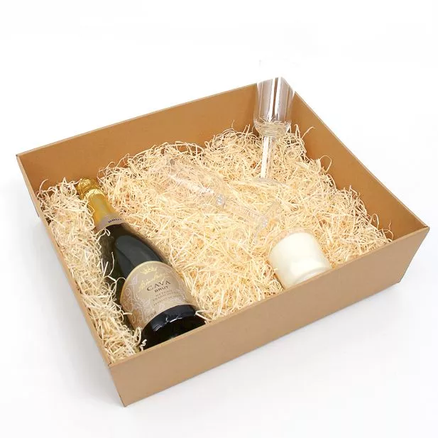 Hamper tray with shredded paper, bottle of champagne and a glass